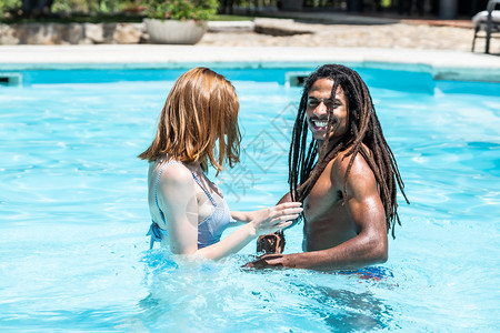 水池白色的非裔美国人男子和白女在游泳池里玩非洲人图片