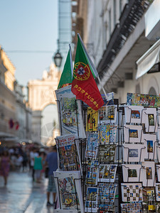 景观商务葡萄牙里斯本商店的参展内明信片和以及背景中的奥古斯塔拱门葡萄牙里斯本商店的参展内明信片和家的背景图片