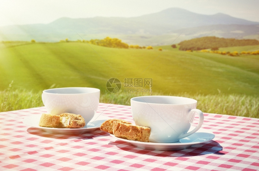 与意大利Toscan风景对抗的桌上咖啡和罐头菜曲奇饼托斯卡纳比科蒂图片
