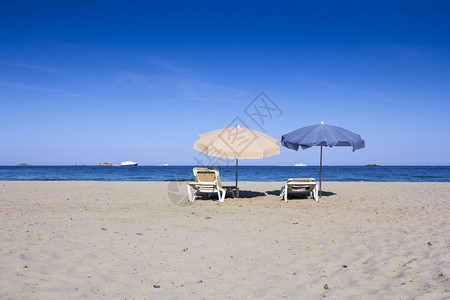 美丽的沙滩椅子和雨伞图片