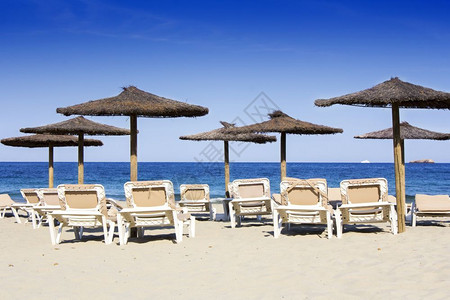 伊比沙岛美丽的沙滩椅子和雨伞背景