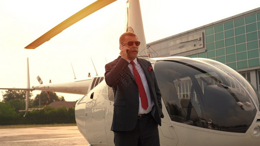 行政人员车辆生意在私直升机附近用手说话的商人使用私直升机图片