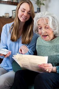 老年人80代家妇女用账单和文件工作帮助高级邻居协会图片