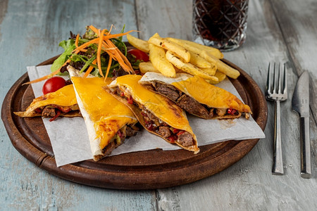 克萨迪亚斯小吃热的墨西哥饼木制桌上有肉奶酪和胡椒番茄背景