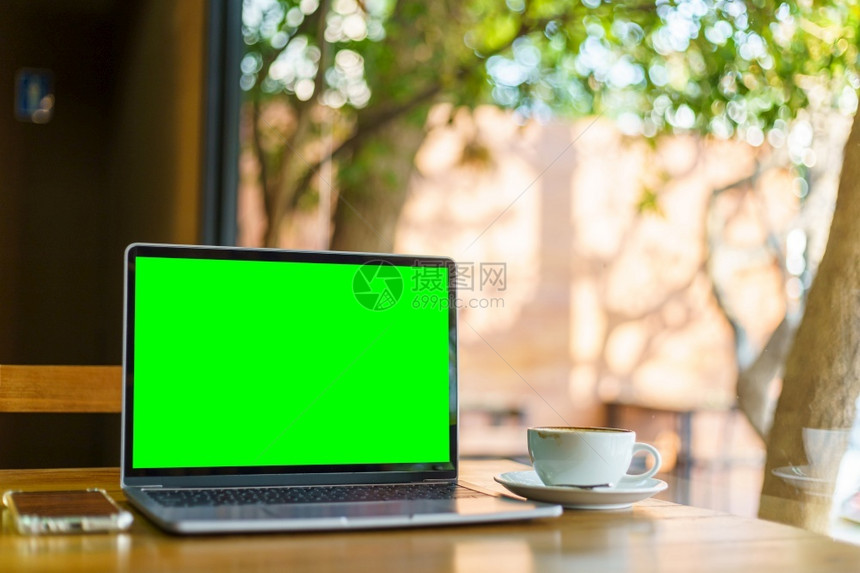 数字的沟通在咖啡店背景的桌子上用空屏幕咖啡杯和智能手机抽装笔记本电脑绿色屏幕键盘图片