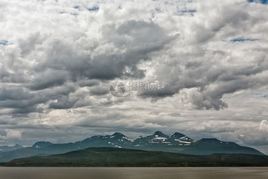 全景峡湾顶峰在多云的天空下挪威安道尔尼斯附近的Romsdalsfjorden沿线的山脉挪威安道尔尼斯附近的沿线图片