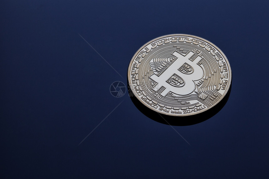 目的金属支付蓝色背景中的加密货币比特虚拟货和商业的概念蓝色背景中的加密货币比特图片