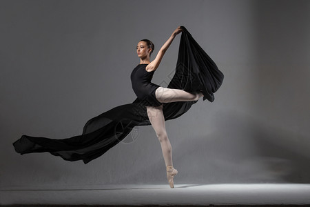 摆姿势穿着黑色紧身衣的优雅芭蕾舞女演员与黑布合影工作室女图片