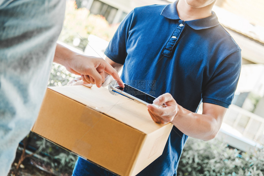 邮差盒子提供亚洲男士服务在顾客户口门前用手拿着箱装的子接送亚洲男服务人图片