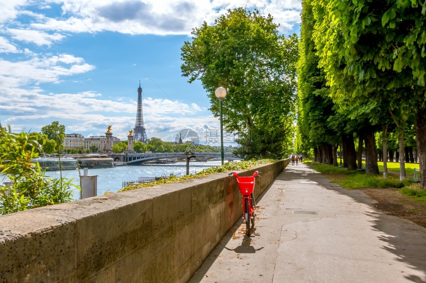 法国巴黎阳光日塞纳河堤岸俯视着西内河桑尼大道上的埃菲尔铁塔明亮红色自行车天的循环图片