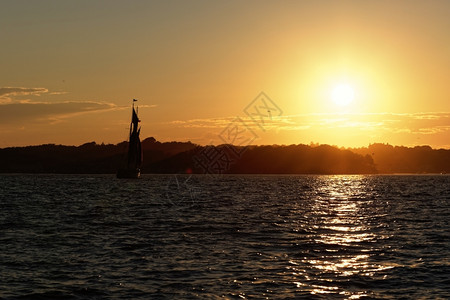 黄昏阳光日落时乘船航行在海洋日落时出宁静图片