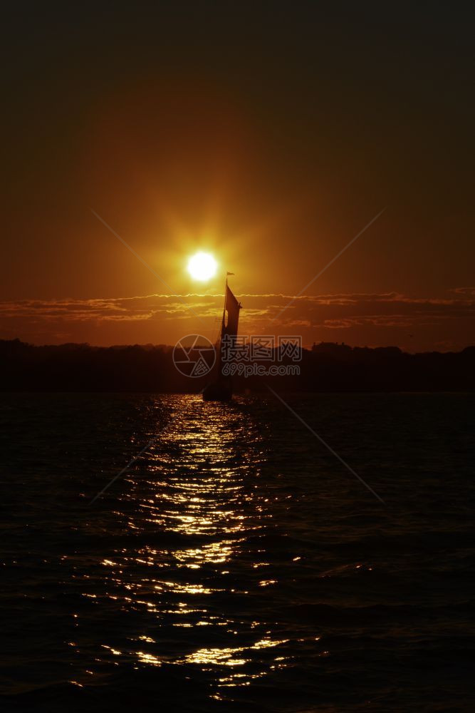 游艇闲暇地平线日落时在海上晒的帆船图片