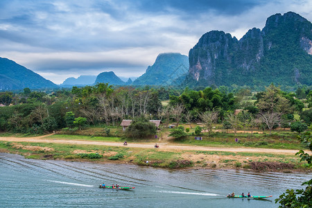 目的地老挝VangVieng的南宋江旅游船和山背景象天空旺图片