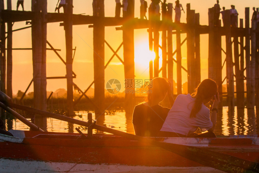喜悦游艇两个女人坐在一条船上看着河边的日落假期图片