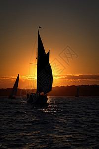 冷静的风海浪在边日落时乘船航行图片