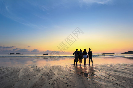 景观太阳日出一群快乐的年轻人在海滩上看着美丽的夏日夕阳图片