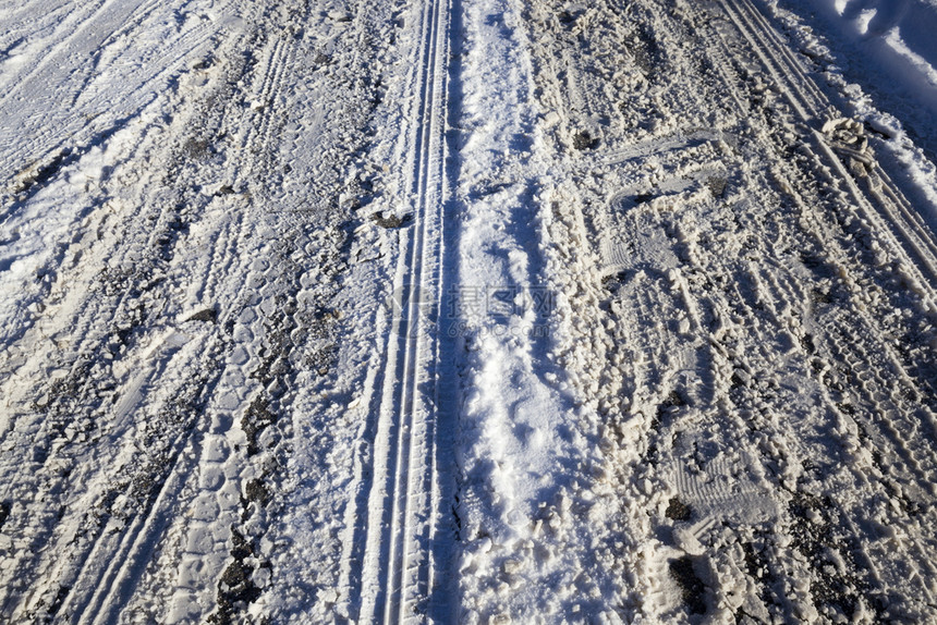 冬季公路包括许多车道和一条简洁紧凑的积雪覆盖不平坦的冬季公路阳光巷道车辆图片