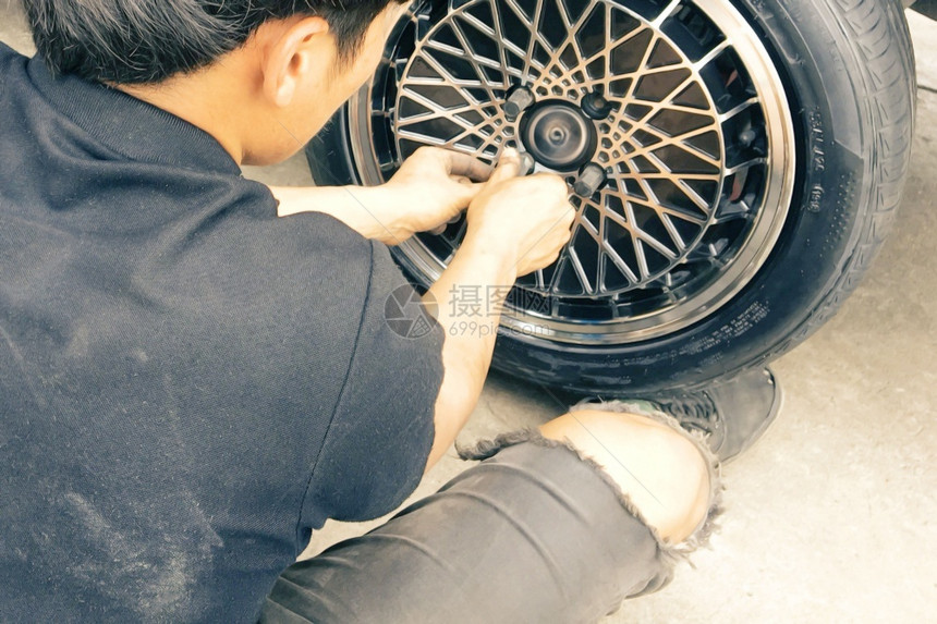 机械师正在收紧车轮坚果以改变车轮户外男人修理工图片