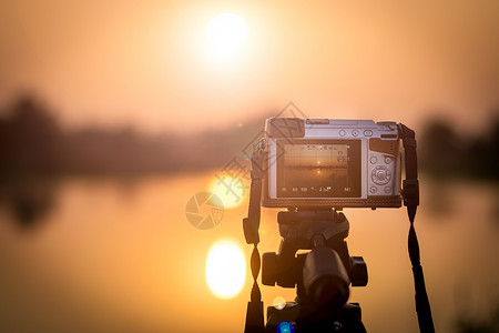 延时拍摄素材现代的镜头将相机设置在三脚架上以记录日落的延时视频轮廓背景