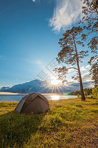 夏天假期阳光在松树下湖岸边的旅游帐篷图片