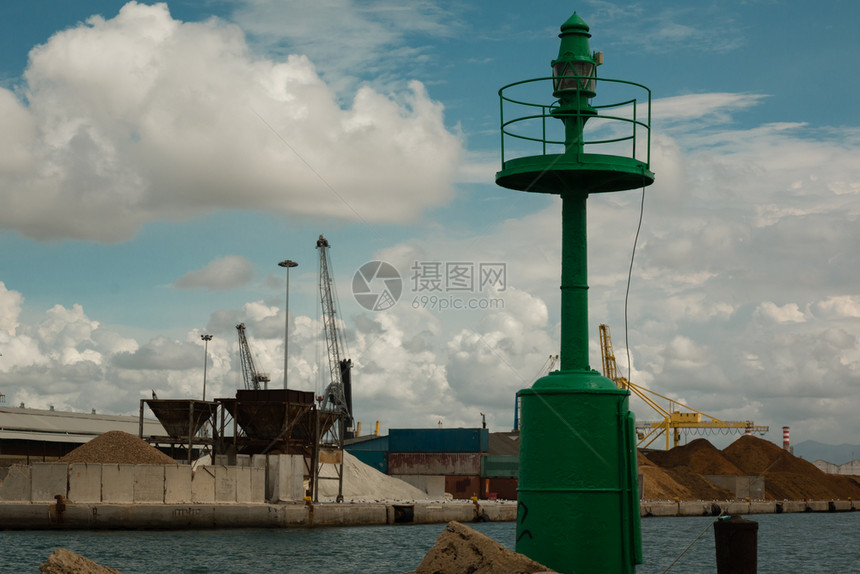 海军院子绿色金属灯塔带云的蓝天空和背景中的造船厂蓝色图片