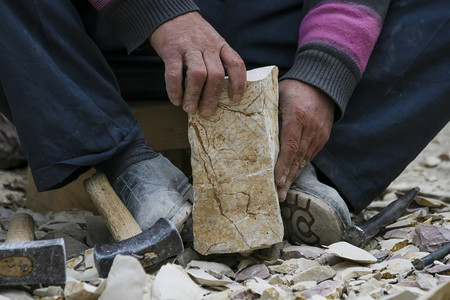 专业的行传统用锤子和摩尔奇碎石工人的手图片