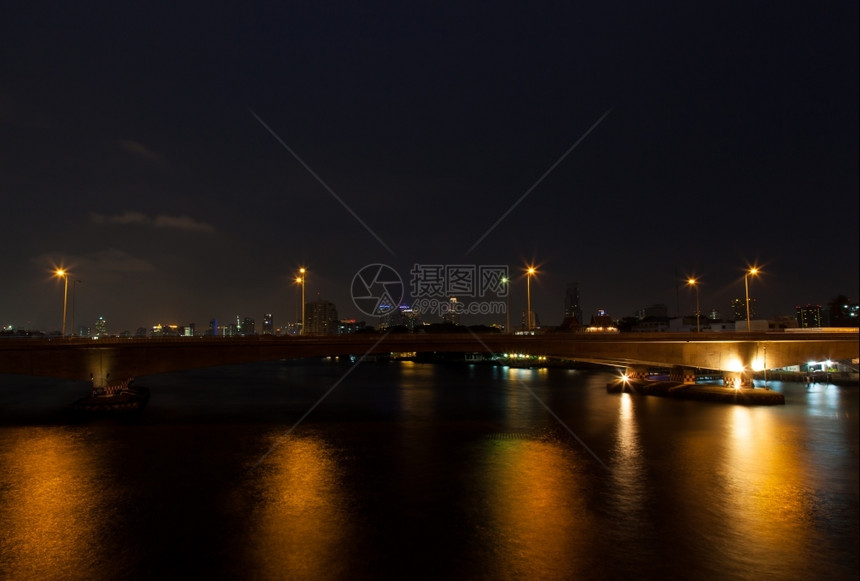 运动夜间穿过河桥有灯光照亮用电跑的汽车和河内桥梁船在旅行城市的图片