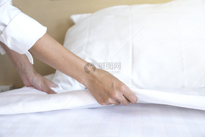 女佣近亲手在酒店房间设置白床单松弛睡觉图片