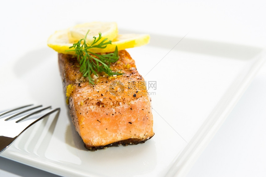 炙烤厨师美味的鲑鱼在白盘上加盐辣椒和柠檬片美食家图片