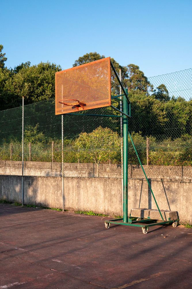 市篮球法院背景的蓝天和树外篮球圈灰色的金属晴天图片
