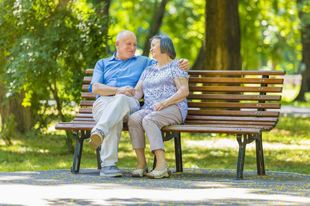 妻子友谊年长夫妇在夏季公园坐长椅上谈话家庭图片