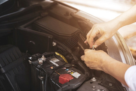 金属在汽车修理服务中心检查汽车发动机的修理工手举起来关心控制图片