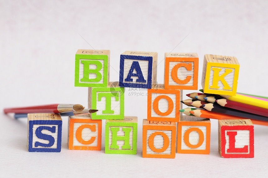 供应回到学校后用白背景的彩色铅笔和油漆显示字母表块拼写回学校颜色金属图片