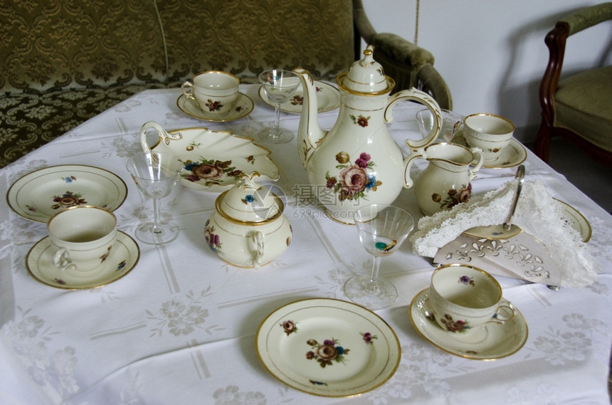 绿色茶壶盘子旧式咖啡桌为茶叶和蛋糕服务图片