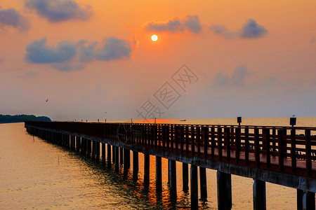 旅行岛清晨海景日出背的长桥海反射图片