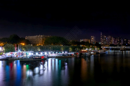 塞纳河水上餐厅在巴黎的夏夜快乐之船停泊在塞纳河堤岸上夜间堤岸有很多彩灯光游轮停靠在塞纳河堤外城市的欧洲旅行背景