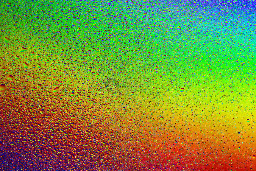 彩虹背景下的水滴及其反射在彩虹背景中的水滴以及彩虹背景上的水滴湿新鲜喷图片