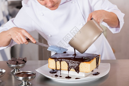工作糖果抹刀厨房的糕点师装饰巧克力蛋糕图片
