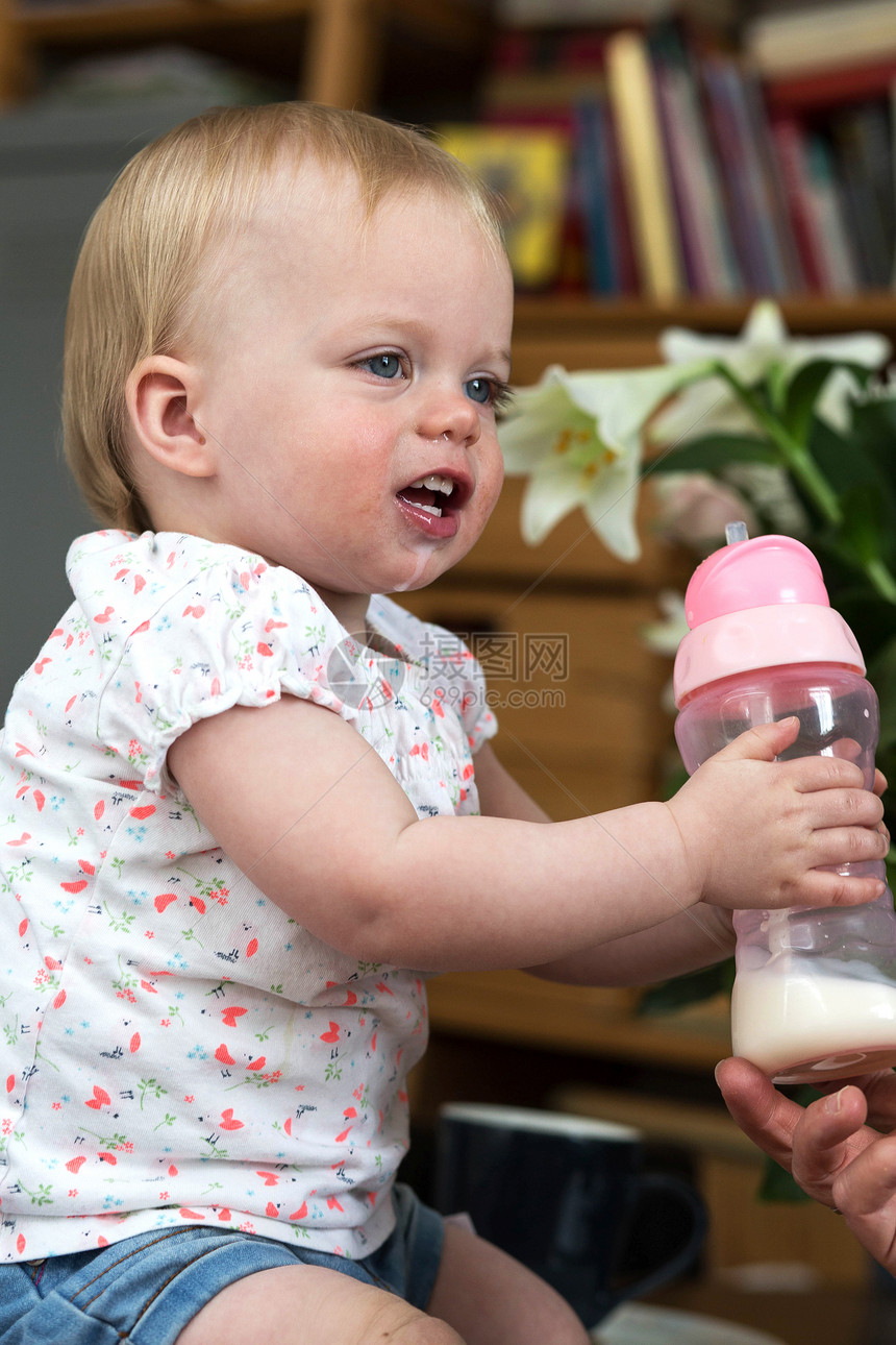 食物吸吮饥饿的用瓶子喝奶孩可爱的婴儿肖像用瓶子喝牛奶的孩可爱的婴儿图片