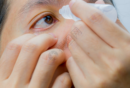 自然眼力成年亚洲妇女在棕色眼睛中应用滴子的成年亚洲妇女推杆图片