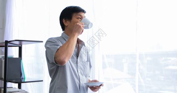 高年亚裔男子在休息时间喝咖啡礼物情人节拥抱图片