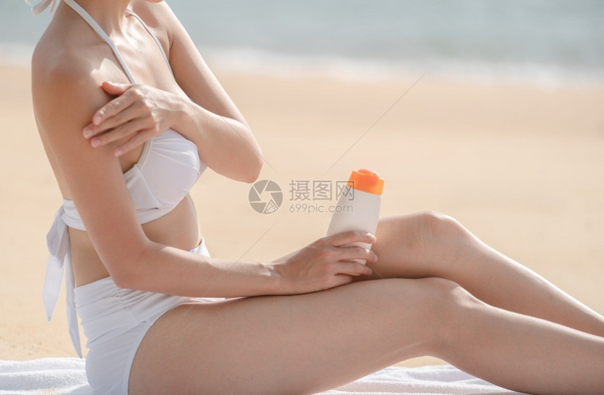 沙滩上的女人使用防晒霜图片