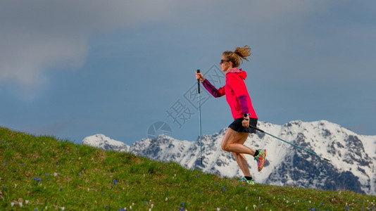 踪迹爬坡道跑步北欧人走着和小步一个女孩带棍棒跑在有雪背景的春山树苗上图片