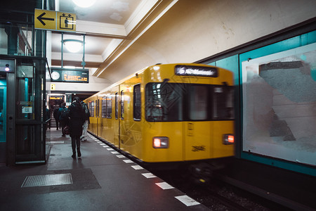 平台德国城市柏林UBahn公共运输地铁内下站的黄色模糊地铁列车图片