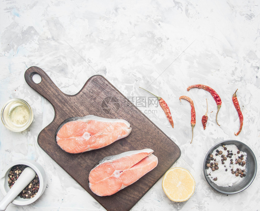 结石鱼片红色的两块美味生鲑鱼牛排加柠檬调味品和白底胡椒放文字的地方图片