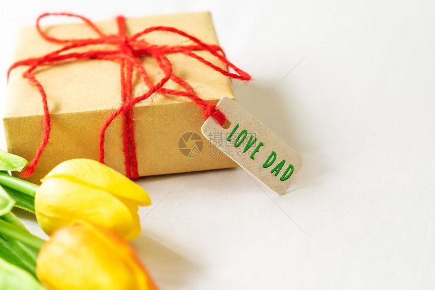 问候白色的天快乐父亲节概念礼物盒和鲜花纸标签与爱爸文本图片