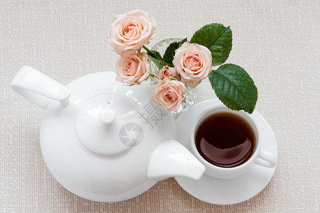 织物粉色的茶壶杯子和玫瑰花在盘子上的茶壶杯和玫瑰食物图片