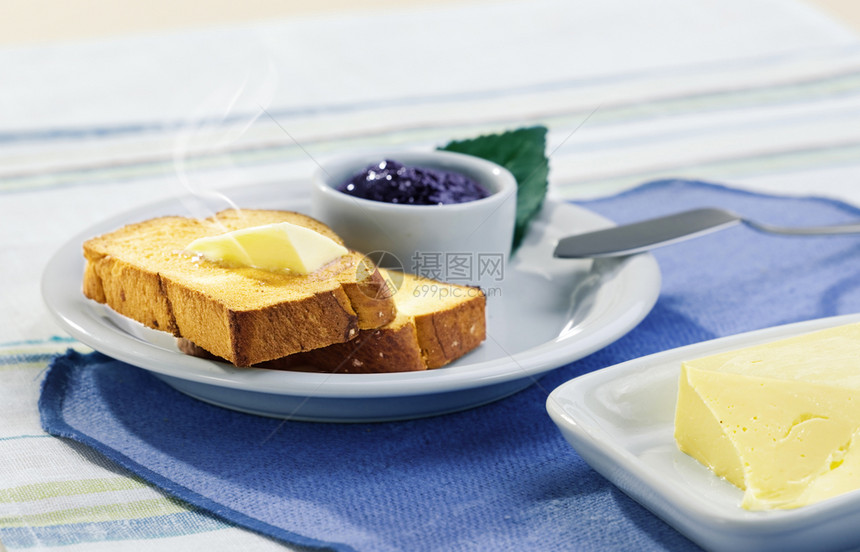 棕色的配面包黄油和果酱的有益健康早餐泡沫快的图片
