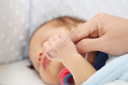 采用孩子抱着母亲手指的睡婴儿团队合作图片