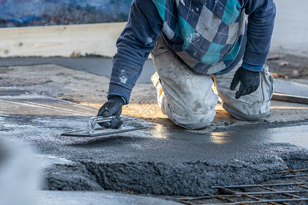混凝土浇注男在建筑工地白天面附近距离靠不明身份工人中路混凝土水泥迫击散落在地下点镘背景